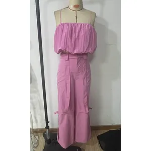 Dettaglio completo due pezzi rosa con crop top a pieghe e pantaloni a gamba larga a vita alta