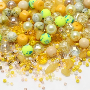 Close-up of mixed 8mm yellow and amber glass beads with irregular stones for DIY jewelry