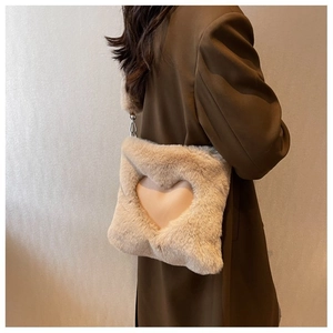 Dettaglio della borsa a tracolla in peluche beige con ritaglio a cuore e fodera rosa