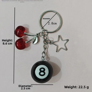 Detail of cherry resin charm with metal star and billiard ball number 8 on silver keychain