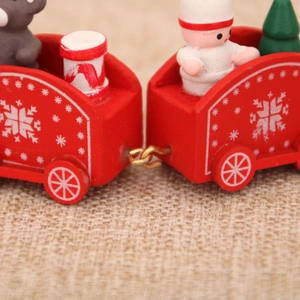 Detailed macro view of red wooden Christmas train carriages connected by golden metal hooks
