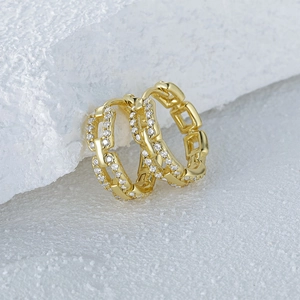 Macro shot of gold hoop earrings featuring a chain-link design with pavé set zircons