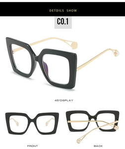 Detail showing oversized black cat-eye glasses with gold metal temples and pearl accents