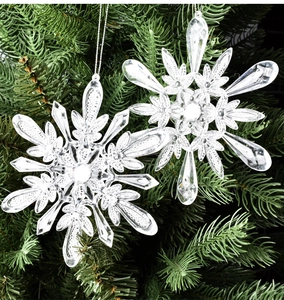 Vue macro de flocons en acrylique transparent sur branches de sapin pour décor de Noël