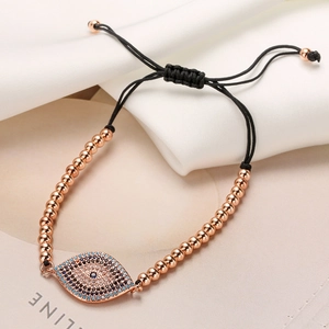 Detail of rose gold evil eye bracelet with blue zircon and adjustable woven cord