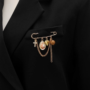 Détail d'une broche vintage dorée avec croix et pendentif portrait sur revers noir