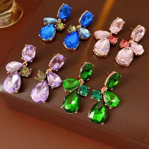 Detail of vintage teardrop earrings set with blue pink purple and green gemstones