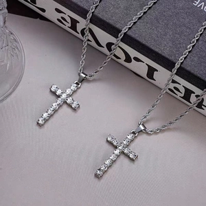 Gros plan de pendentifs croix en argent sertis de zircons sur chaînes torsadées