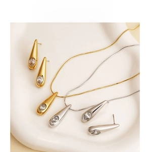 Nahaufnahme von Tropfen-Halskette und Ohrringen aus Zirkon in Gold und Silber