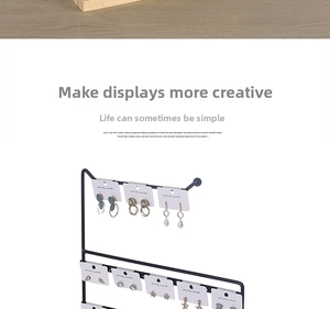 Detail of multi-tier black metal earring display stand with white cards for jewelry retail