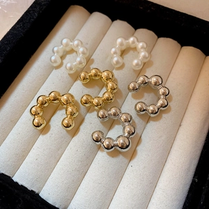 Primo piano dettagliato di un set di 6 earcuff a forma di C con perle e metallo dorato