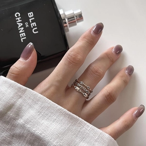 Minimalist silver chain rings set with CD logo and pig nose links on woman finger