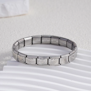 Macro detail of Italian charm bracelet links with heart engravings in stainless steel