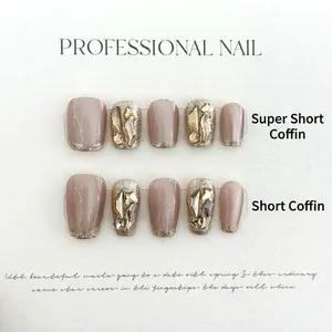 Gros plan d'ongles ballerine gris thé au lait avec paillettes et strass 3D