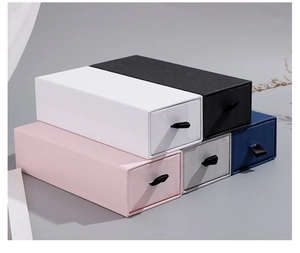 Stack of colorful drawer-style gift boxes with ribbon pulls in various textures