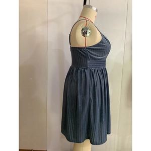 Détail de la robe sans manches plissée bleu foncé avec texture maille et taille haute