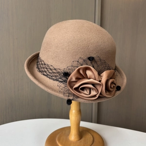 Detailed view of elegant wool felt hat with mesh veil and handcrafted silk flowers decor
