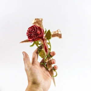 Detalle del molde de cruz con clavos dorados y rosa roja para decoración pared