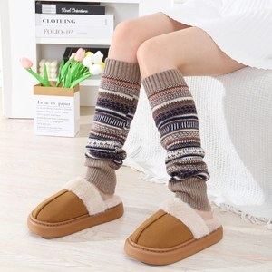 Détail de jambières en tricot bohème assorties à des chaussons en peluche marron