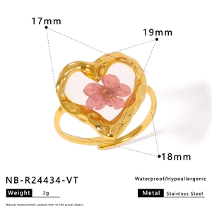Macro detail of heart-shaped stainless steel ring with real pink dried flower inlay