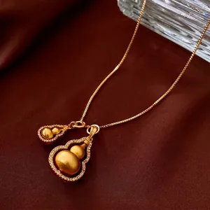 Gold plated double gourd necklace with sparkling cubic zirconia on brown silk