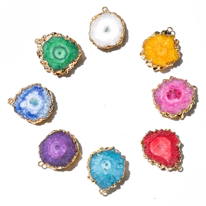 Detail of colorful agate slice pendants with gold plated edges in various natural stone hues
