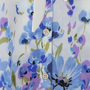 Floral print shirt for women featuring blue purple pattern and gold rimmed buttons