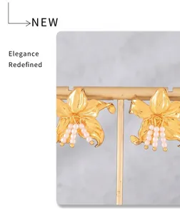Detail of 18k gold plated flower stud earrings with hanging imitation pearl tassels