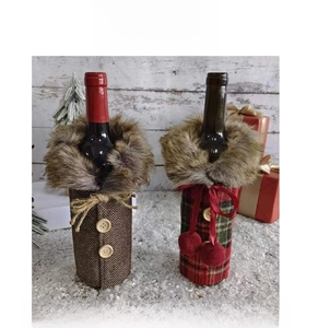Detailed front view of Christmas wine bottle covers in red plaid and herringbone fabric