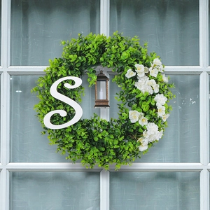 Christmas wreath with eucalyptus leaves, vintage lantern, and large white letter S on window