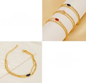 Detail of double-layer gold Figaro chain bracelet with marquise-cut zircon stones