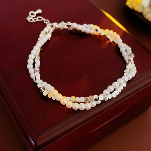 Detail of double-layer pearl bracelet with silver geometric beads on jewelry box