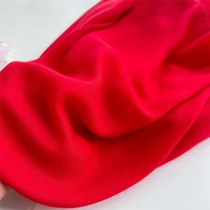 Close-up of red cotton linen fabric texture with soft natural pleats and drapery