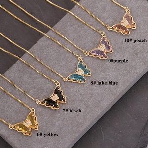 Detailed flat lay of butterfly pendant necklaces in various colors and 18K gold plating