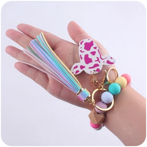 Detail of western cow print charm with rainbow tassel and colorful silicone beads