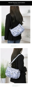 Detail of light blue nylon crossbody bag with white polka dots and adjustable strap