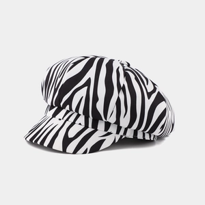 Detail view showing black and white zebra pattern and twill texture of the octagonal newsboy cap