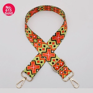 Detail of ethnic style woven bag strap with orange-green patterns and gold hardware
