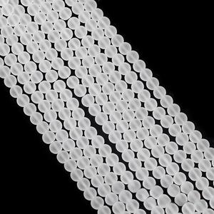 Macro shot of matte white frosted round glass beads arranged in a neat diagonal pattern