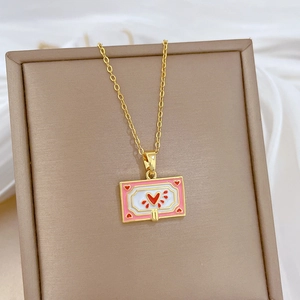 Detail of gold heart pendant with pink enamel border and rhinestones on soft fabric