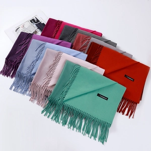 Close-up of multicolored cashmere scarves with fringe and authentic material labels