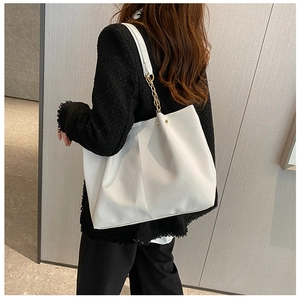 Gros plan d'un grand sac cabas blanc en cuir avec bandoulière chaîne sur un modèle