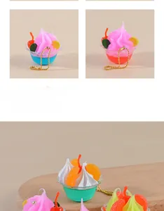 Close-up of miniature faux ice cream sundae charms with colorful fruit toppings and gold chains