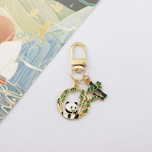 Macro view of panda keychain with bamboo charm and gold metal hook for bags