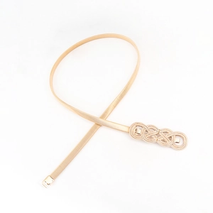 Macro detail of elastic golden metal spring belt with vintage interwoven knot buckle