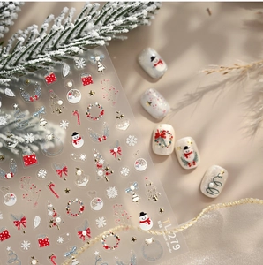 Macro detail of Christmas nail art stickers with gold embossed trees and snowflakes