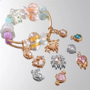Golden double-layer beaded bracelet with moon and heart charms on a reflective surface