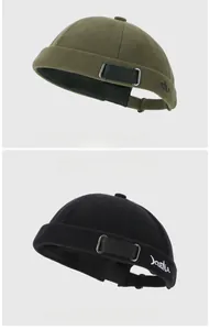 Detail of army green and black Miki hats featuring embroidered letters and adjustable metal buckle