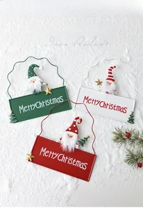 Detailed close-up of iron Christmas pendants with gnomes and Merry Christmas lettering