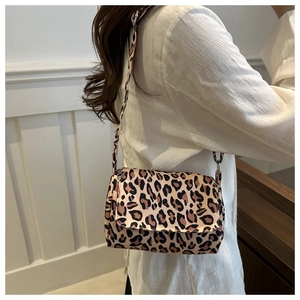 Detail of leopard print crossbody bag with adjustable strap worn by a female model